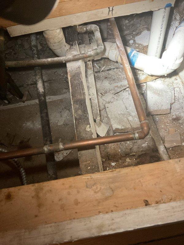 Responded to service call for multiple bathroom plumbing issues. Inspected toilet with reported running condition and broken seat. Assessed toilet tank components including flapper valve, fill valve, and flush mechanism for continuous water flow issue. Documented existing two-piece toilet condition and accessibility of supply line connections. Inspected crawl space plumbing infrastructure beneath bathroom, including copper and PVC drain lines to evaluate replacement feasibility. Photographed toilet fixture and underlying plumbing system for customer review regarding potential full toilet replacement versus component repair options.