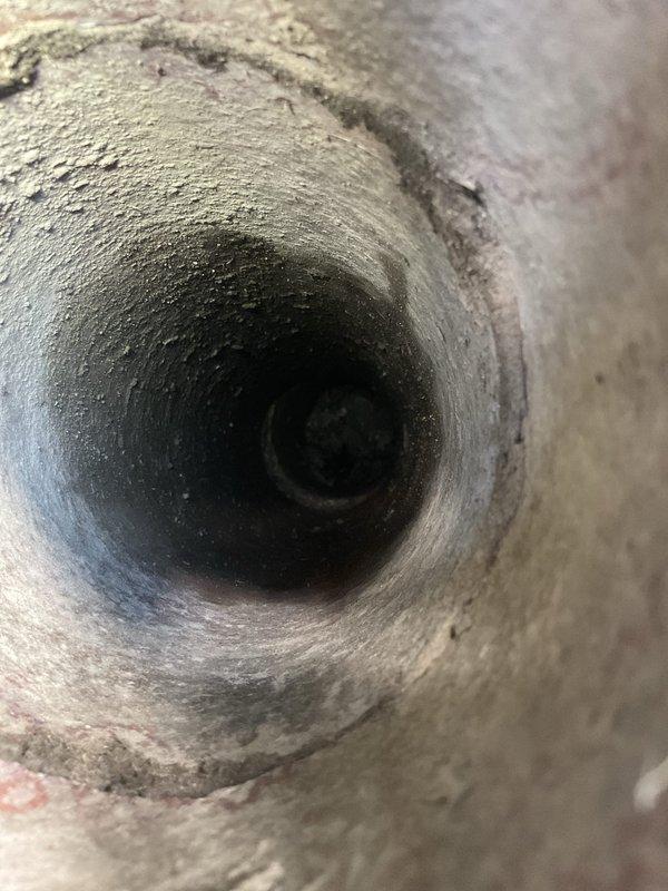 Responded to clogged drain service call at residential property. Upon arrival, inspected exterior drainage system including floor drain and drainage pipe opening on concrete patio area. Found significant blockage and debris accumulation in drainage duct system. Performed thorough cleaning of affected drain line, removing heavy buildup of lint, dust, and fibrous material that had accumulated along interior pipe walls over extended period. Cleared obstruction to restore proper drainage flow. Documented pre-service conditions showing extent of blockage and completed work with photographic evidence.