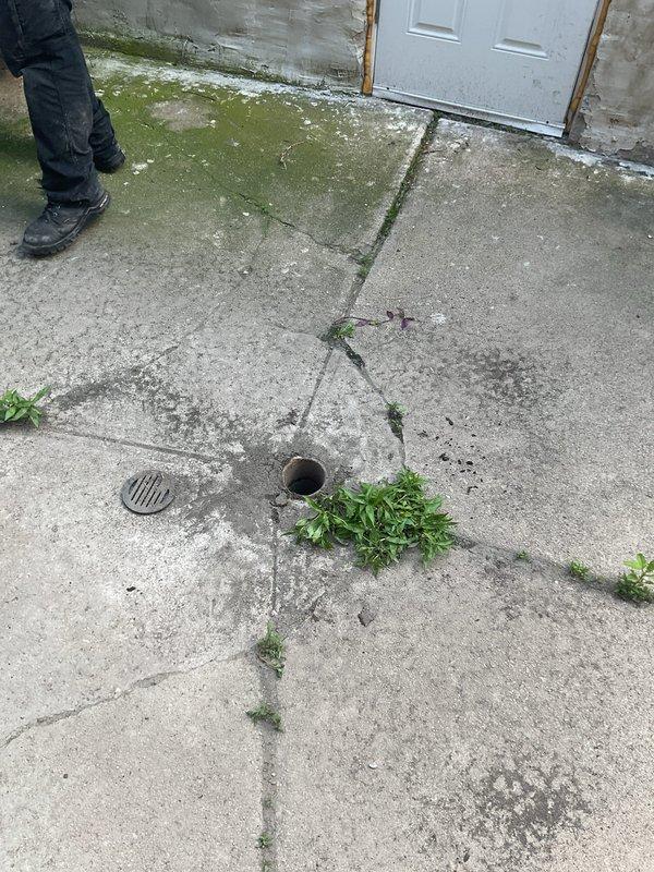 Responded to clogged drain service call at residential property. Upon arrival, inspected exterior drainage system including floor drain and drainage pipe opening on concrete patio area. Found significant blockage and debris accumulation in drainage duct system. Performed thorough cleaning of affected drain line, removing heavy buildup of lint, dust, and fibrous material that had accumulated along interior pipe walls over extended period. Cleared obstruction to restore proper drainage flow. Documented pre-service conditions showing extent of blockage and completed work with photographic evidence.