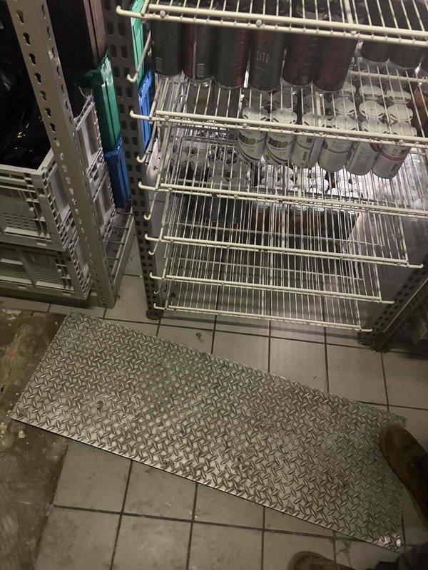Conducted on-site plumbing estimate for commercial kitchen piping requirements. Assessed existing infrastructure and photographed storage area containing wire shelving units to document current conditions and determine piping routing options. Evaluated floor layout, including diamond-plate matting placement, and identified potential pathways for new plumbing lines while considering existing ductwork and equipment placement to ensure proper installation access and code compliance.