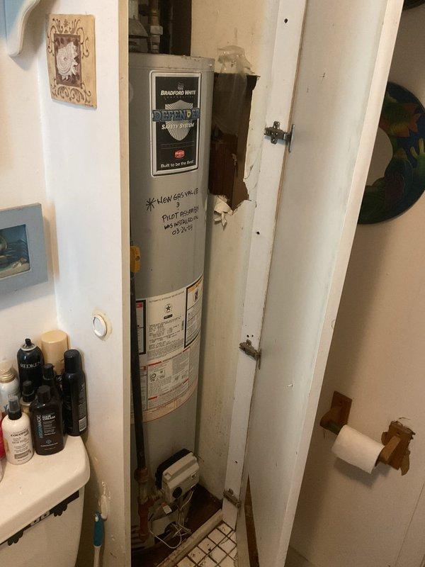 Responded to priority call for water leak originating from above bathroom in century-old home. Upon investigation, inspected Bradford White water heater located in narrow utility closet adjacent to bathroom and accessed attic space above to identify leak source. Examined HVAC system, plumbing connections, and surrounding infrastructure in attic crawl space with reflective insulation. Assessed water heater installation, supply lines, and drainage connections to determine origin of moisture intrusion affecting bathroom ceiling below.