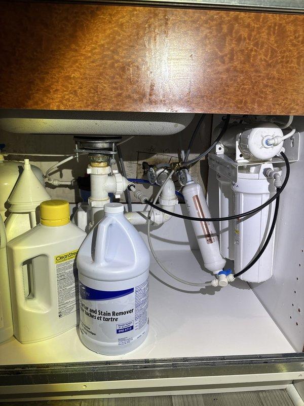 Responded to emergency call for burst pipe in commercial office building with century-old plumbing infrastructure. Upon arrival via back entrance, located and isolated the failed section of piping in the under-sink cabinet area. Inspected existing plumbing system including garbage disposal connections, PVC drain lines, and water supply lines with filtration system. Replaced damaged pipe section and verified integrity of surrounding connections, including flexible supply lines, shut-off valves, and braided stainless steel hoses. Tested all connections for leaks and confirmed proper water pressure restoration throughout the affected area.