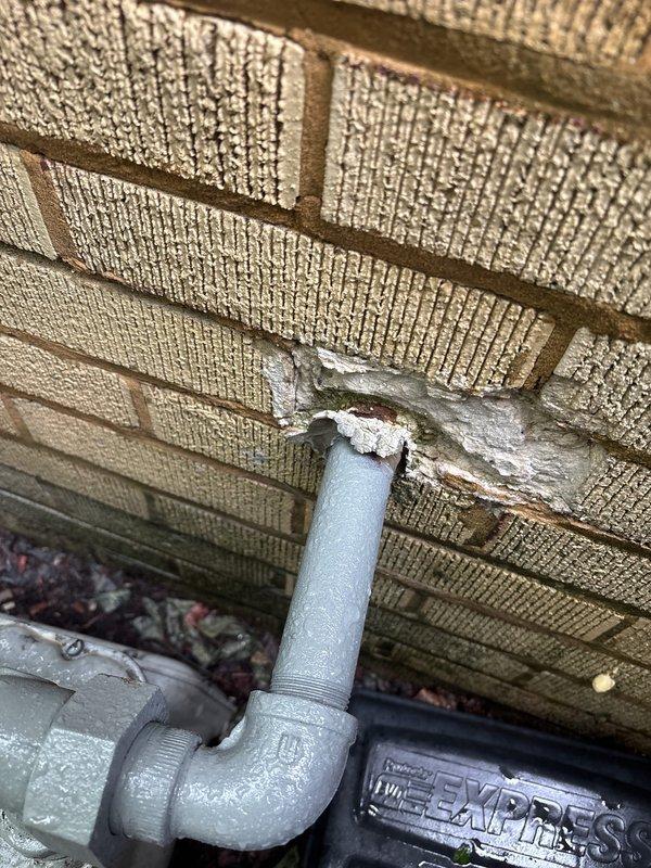 Responded to service call for multiple gas leak concerns at property, including leak at water heater connection point and two additional gas leak locations. Upon arrival, conducted thorough visual inspection of exterior gas piping system mounted against foundation wall. Identified deteriorated pipe connections with visible corrosion and worn protective coating on threaded fittings near water heater installation point. Performed comprehensive pressure test on gas line system to verify integrity and locate all leak sources. Inspected exterior gas meter assembly and associated shutoff valves positioned in landscaped area with visible weathering on pipe surfaces. Documented existing conditions of aged piping infrastructure showing signs of paint deterioration and potential compromise points at wall penetrations. All identified leak locations were assessed and documented photographically for repair recommendations.