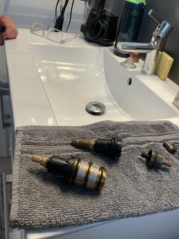Responded to emergency plumbing call for shower valve leak with tub filling uncontrollably and water unable to be shut off. Diagnosed failed shower valve cartridges causing continuous water flow and loss of shut-off control. Removed and replaced defective valve cartridges to restore proper water control and eliminate leak, preventing potential flooding damage.