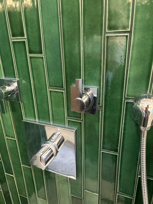 Responded to priority service call for malfunctioning Grohe thermostatic shower control in 1954-built home. Upon inspection, diagnosed that the volume control handle had stripped internal teeth, preventing engagement with the valve stem and rendering the shower inoperable. Removed the defective handle assembly, verified valve stem condition, and installed replacement handle with proper tooth engagement to restore full operational control of the shower system.