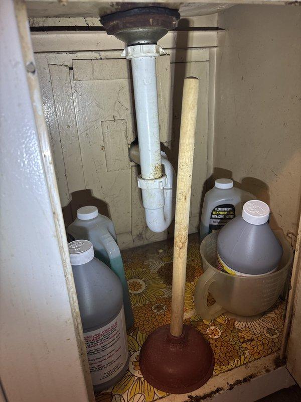 Responded to priority water leak repair in kitchen area where water was seeping up through the floor. Upon inspection, identified leak originating from under-sink plumbing system, specifically at the PVC drain pipe connection to the sink drain fixture. Inspected all visible plumbing connections beneath the sink, noting discoloration and residue on the lower portion of the drain pipe indicating active moisture intrusion. Repaired the compromised connection, tested the system for proper drainage and seal integrity, and confirmed no further water leakage through the kitchen floor.