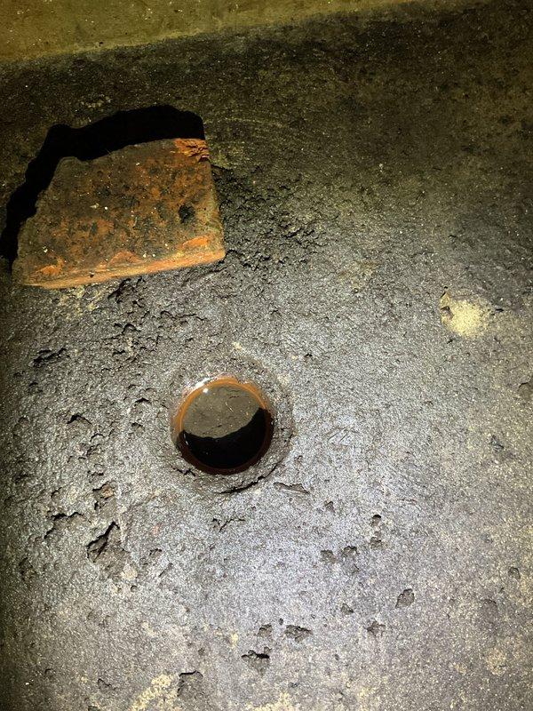 Responded to a backup condition at floor drain located near stairwell. Upon arrival, found drain experiencing water backup with visible signs of deterioration and corrosion around the drain opening. Inspected the affected area and documented existing conditions including rust staining around drain rim and debris accumulation on surrounding concrete surface. Assessed drainage system and identified blockage causing the backup issue. Cleared obstruction from drain line to restore proper flow and functionality. Verified drainage was operating correctly upon completion of service.