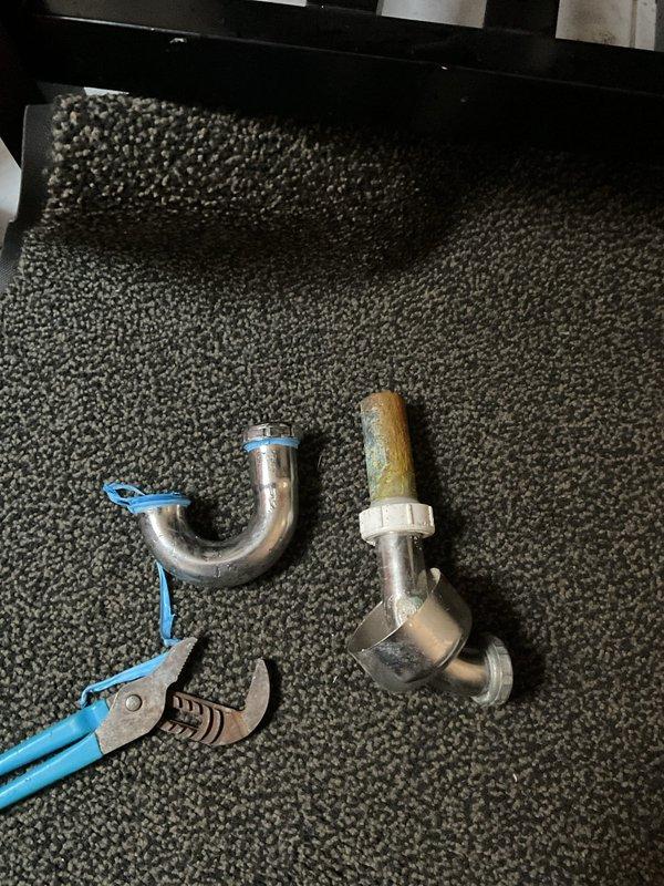 Responded to clogged bathroom sink drain at residential property. Upon inspection, attempted to clear blockage using drain rod/snake. During rodding process, damaged existing drain piping, causing crack in the line. Removed and replaced damaged P-trap assembly and connecting drain fittings beneath vanity sink. Installed new chrome-finished P-trap with proper seals and connections. Tested drainage system to verify proper flow and confirmed no leaks at connections. Customer elected to proceed with necessary repair work.