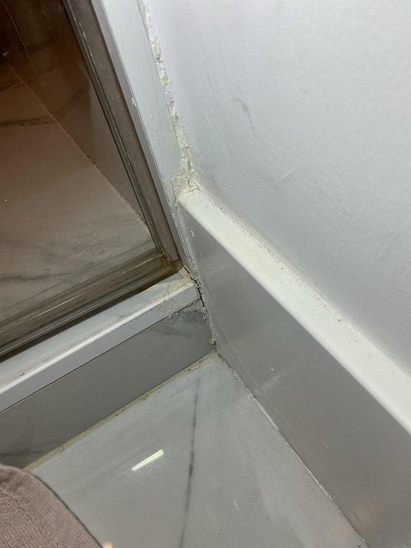 Responded to water leak in guest bathroom originating from plumbing pipe. Upon inspection, identified compromised window frame sealing and deteriorated caulking contributing to moisture infiltration. Accessed ceiling cavity through existing access panel to locate source of leak in overhead plumbing. Documented existing conditions including paint deterioration, failed sealant material, and water damage evidence around window frame perimeter. Photos taken of affected areas for record and authorization purposes.