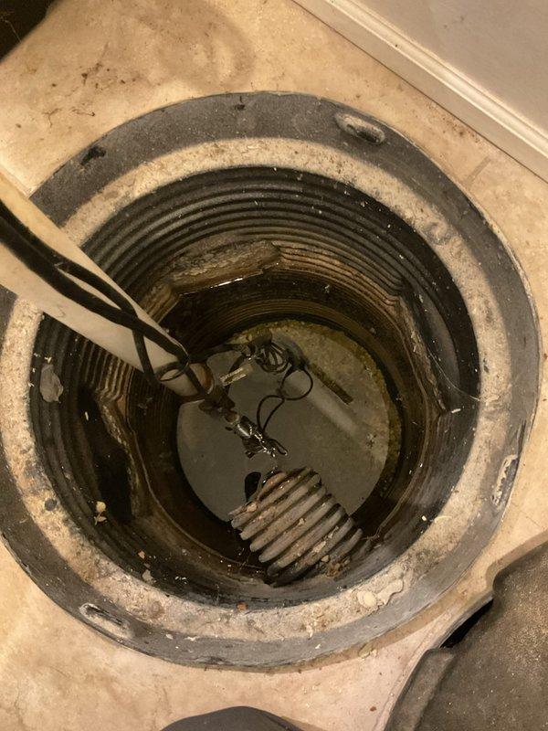 Conducted a sump pump replacement estimate for an existing system installed in 2016. The current pump is functioning properly but the customer is seeking proactive replacement due to the age of the equipment. Inspected the concrete basin sump pit, which showed typical mineral deposits and sediment accumulation along the interior walls, and evaluated the existing pump unit and discharge piping configuration. Documented the installation with photos showing the cylindrical basin construction, water level, pump positioning, and surrounding basement floor conditions. Provided replacement recommendations for updated sump pump equipment to ensure continued reliable basement water management.
