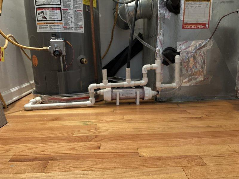 Responded to utility room leak affecting unit below caused by clogged area floor drain overflow. Conducted comprehensive inspection of existing drainage configuration and identified multiple code and safety concerns requiring remediation. Primary issues include undersized area drain pipe inadequate for combined furnace and water heater discharge, drain pipe positioned below finish floor level without proper sealing, and improperly combined furnace and water heater pan drains requiring independent routing. Additional deficiencies noted include absence of water detection alarms, missing wet sensor cut-off switch on furnace, aging condensate neutralizer requiring replacement, lack of floor sealing in utility room, and water heater showing no evidence of routine maintenance. Provided detailed recommendations for corrective measures including drain line upsizing, proper floor penetration sealing, separation of condensate drain lines, installation of water alarms and safety switches, condens