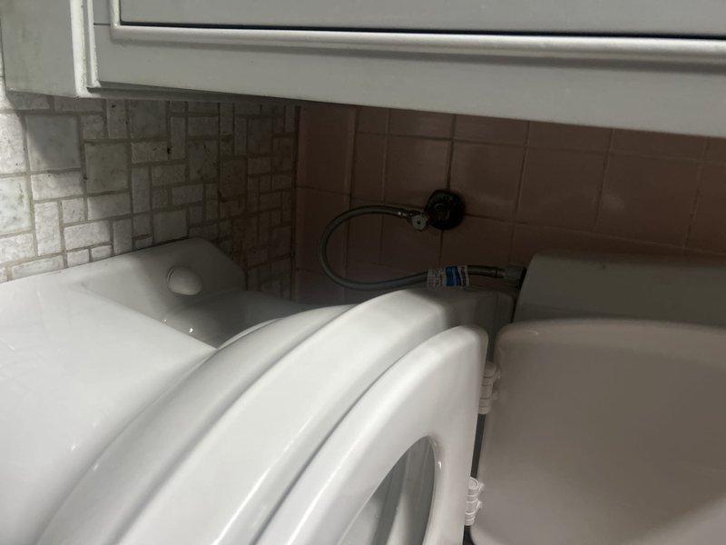 Responded to service call for toilet installation on main level. ADA-compliant toilet currently unavailable and in shop for procurement. Assessed installation site and confirmed readiness for replacement toilet fixture once unit becomes available. Documented existing bathroom fixtures including dual basin sink configuration and floor drain conditions showing age-related staining and mineral deposits on octagonal tile flooring. Customer acknowledged and approved additional charges for secondary toilet installation work to proceed upon arrival of ADA-compliant unit.