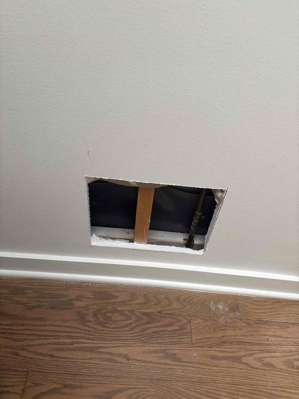 Responded to emergency water leak affecting multiple floors of residence. Upon arrival, confirmed active heavy flow leak originating from third-floor bathroom shower, penetrating through ceiling into kitchen and main living area on second floor, and continuing down into basement level. Performed diagnostic investigation by cutting access opening in wall near baseboard to expose plumbing infrastructure and identify leak source. Inspected third-floor bathroom with glass shower enclosure, marble-style tile walls, and mosaic floor to trace water intrusion path through building structure. Documented damage locations and plumbing system configuration through photography for repair planning and insurance documentation purposes.