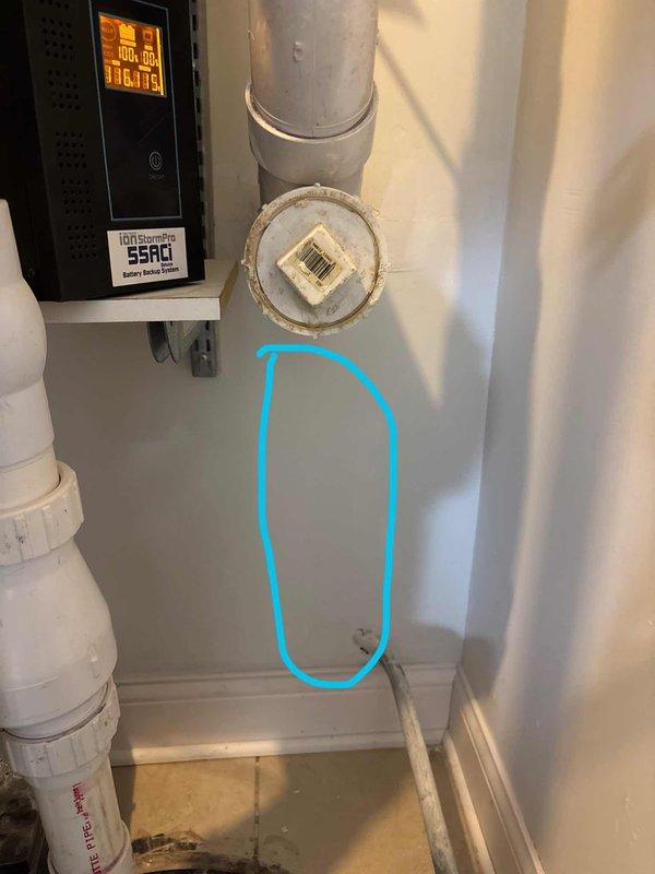 Responded to water leak in basement utility room following storm event. Upon inspection, identified active leak from pipe penetration through back wall near pump equipment, evidenced by vertical water marks on drywall and moisture accumulation on floor tiles. Traced leak source to compromised pipe collar at wall penetration point. Assessed surrounding plumbing infrastructure including water heater connections, PVC drainage lines, and copper supply lines for related damage. Documented moisture damage and leak location with photographic evidence showing water staining on utility room floor and wall penetration area. Recommended repair of pipe collar seal and monitoring of wall cavity for potential hidden moisture damage behind drywall.