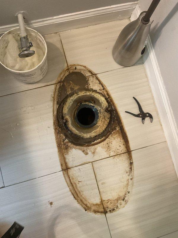 Responded to water leak complaint behind bathroom toilet in 90-year-old residence. Upon inspection, discovered deteriorated wax ring seal and corroded toilet flange causing water seepage onto floor. Removed toilet to access flange assembly, revealing significant rust buildup and wax ring failure. Replaced failed wax ring with new seal, cleaned and prepared flange mounting surface, and reinstalled toilet with proper seal compression. Verified no active leaks during testing and confirmed secure toilet mounting. Cleaned affected floor area and disposed of deteriorated components.