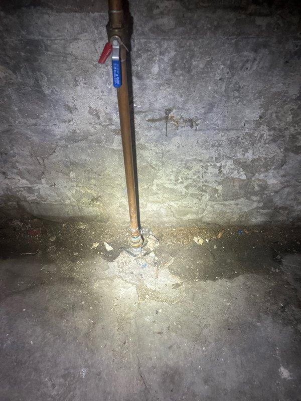 Conducted assessment of existing water service line that was not compliant with current plumbing codes. Evaluated the outdated piping system including a vertical copper pipe installation with ball valve in the basement utility area. Inspected the water service entry point, floor mounting connections, and associated drainage infrastructure including sump pit with pump components. Documented all existing conditions and code violations to prepare comprehensive estimate for complete water service line replacement with code-compliant materials and installation methods.