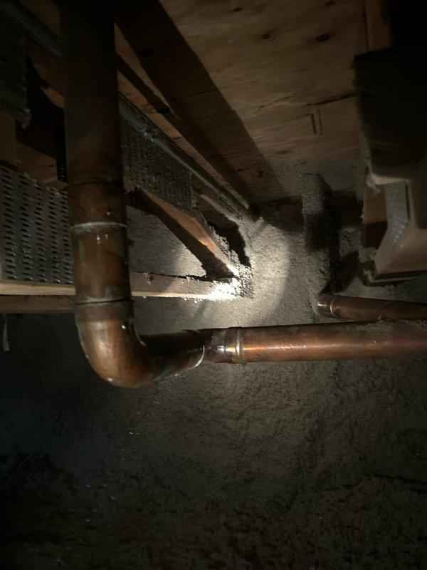 Responded to crawl space inspection revealing severe mold contamination on floor joists, plywood sheathing, and copper plumbing lines. Documented extensive white fungal growth blanketing wooden structural members and piping system, indicating prolonged moisture intrusion. Assessed aged copper trap configuration and surrounding infrastructure for water damage and structural integrity. Sold comprehensive mold remediation and moisture control repair to address contaminated crawl space conditions and prevent further deterioration of building components.