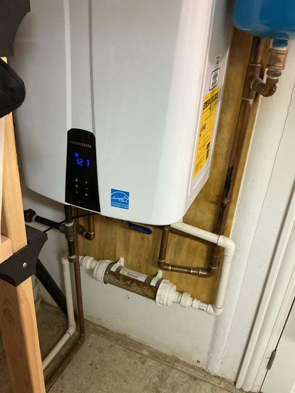 Performed routine maintenance flush on 6-year-old Navien tankless water heater operating within normal parameters. Descaled heat exchanger, flushed system with cleaning solution, inspected internal components including circulation pump and combustion assembly, verified all connections and PVC venting, and confirmed unit returned to proper operation with no issues identified.
