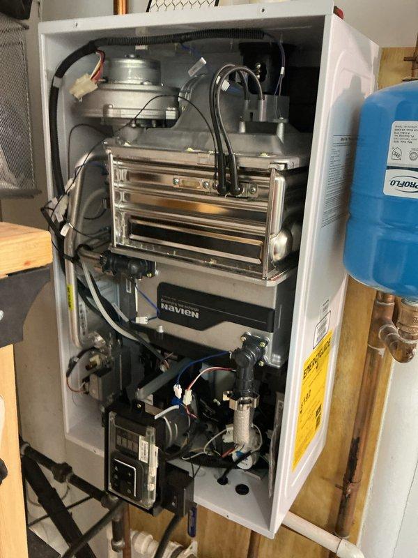 Performed routine maintenance flush on 6-year-old Navien tankless water heater operating within normal parameters. Descaled heat exchanger, flushed system with cleaning solution, inspected internal components including circulation pump and combustion assembly, verified all connections and PVC venting, and confirmed unit returned to proper operation with no issues identified.