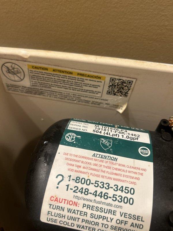 Serviced Kohler pressure-assist toilet equipped with Flushmate MHBS-4K1 pressure vessel system (1.0 gpf). Contacted customer to confirm arrival time and obtain service authorization prior to commencing work. Inspected and documented pressure vessel components, verifying proper labeling and safety specifications, and assessed overall toilet condition including tank lid and bowl assembly.