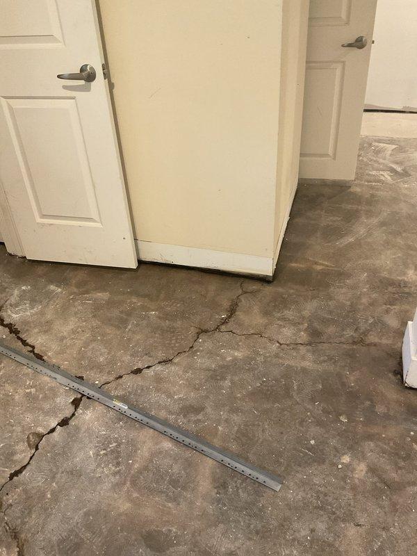 Responded to water intrusion issue where groundwater was entering through multiple foundation cracks in concrete floor. Upon arrival, documented extensive cracking patterns throughout the interior space, with water seeping up through fissures in the foundation slab. Previous drain tile installation had been completed, but continued water infiltration indicated need for additional assessment and estimate for comprehensive waterproofing solutions to address ongoing foundation water penetration.