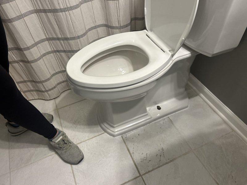 Responded to toilet leak causing water damage to downstairs condo unit in 50-year-old building. Upon inspection, identified deteriorated wax ring seal at toilet base allowing water to seep through floor assembly. Removed toilet, scraped old wax ring, inspected flange for damage, and installed new wax ring seal. Reinstalled toilet with proper alignment, tightened closet bolts to manufacturer specifications, and tested for leaks. Verified floor drain in bathroom showed signs of age-related staining but remained functional. Advised monitoring downstairs unit for further moisture intrusion and recommended follow-up inspection if leaking persists.
