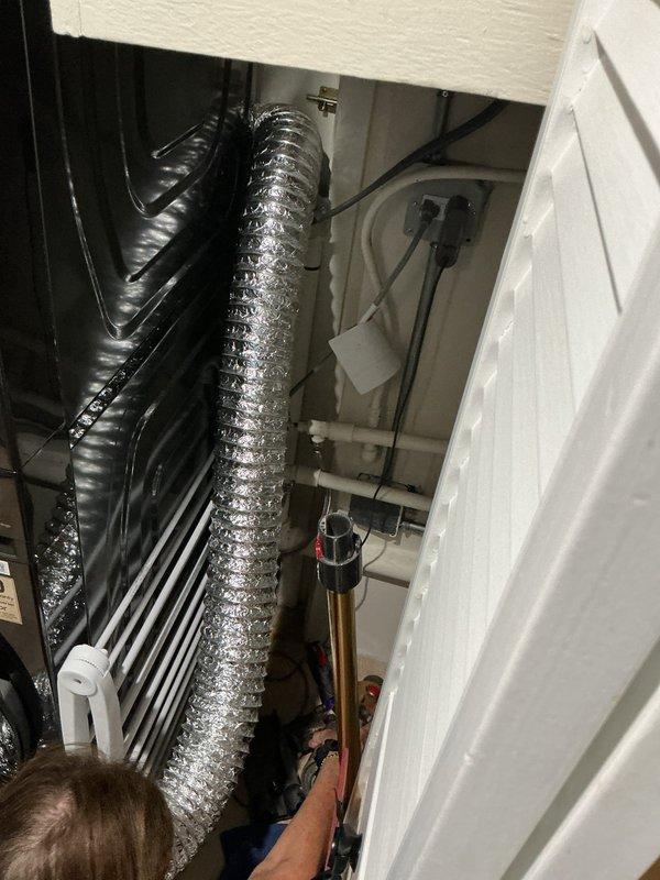 Performed reverse osmosis system maintenance by accessing the water treatment equipment and replacing the RO filter cartridge. Inspected system components including the storage tank, brass filter housing with black valve assembly, and associated plumbing connections to ensure proper operation and verify no leaks were present after filter replacement.