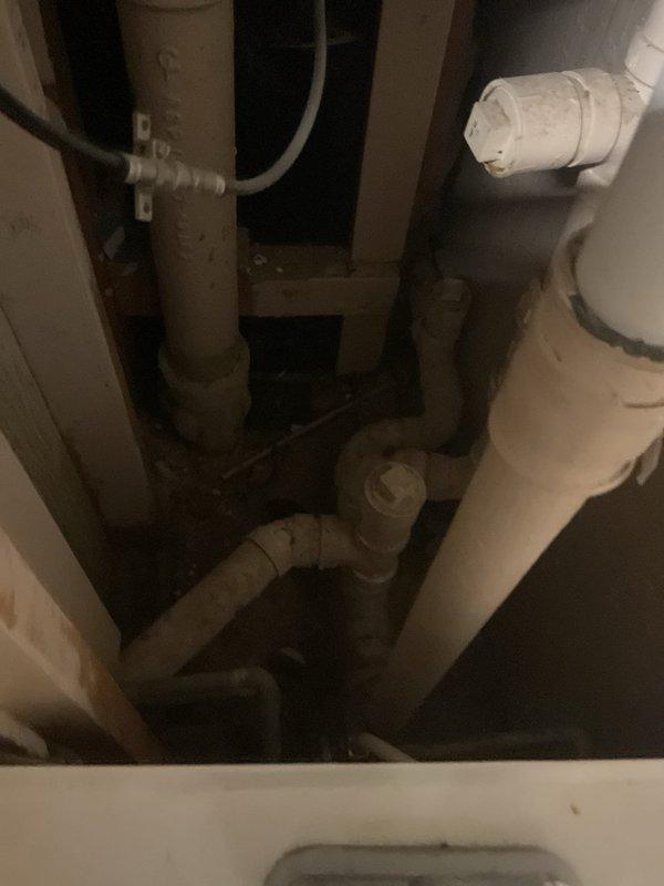 Performed on-site evaluation for hydro-jetting service requirements at residential property. Inspected interior plumbing infrastructure beneath bathroom vanity, documenting existing drain line configuration including P-trap assemblies and PVC pipe connections showing age-related wear. Assessed exterior foundation area and identified drainage access points near landscaped perimeter for potential jetting equipment positioning and mainline access. Captured photographic documentation of plumbing conditions to provide accurate estimate for hydro-jetting services.