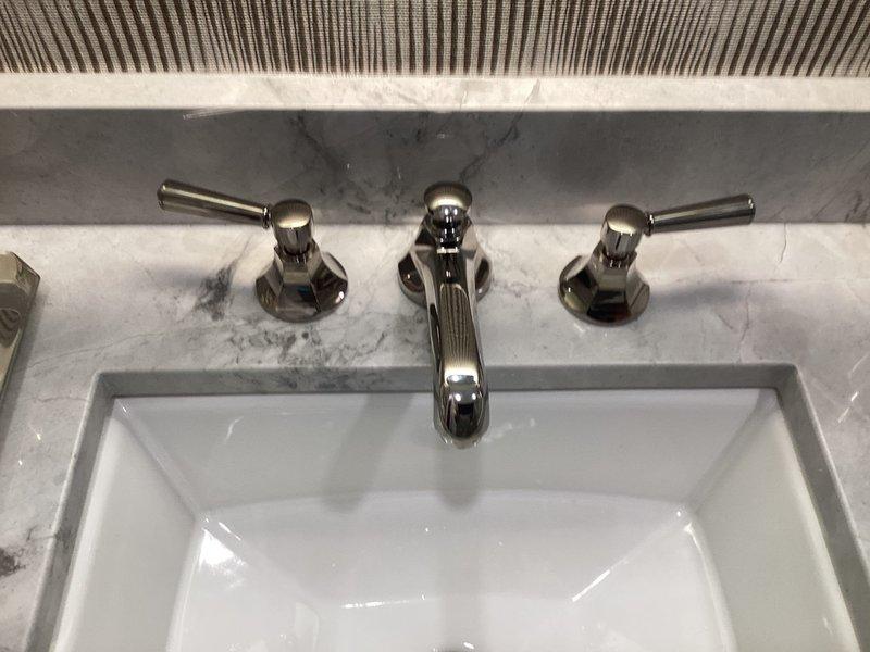 Senior technician dispatched to address faucet installation issues from previous service visit. Upon inspection, verified proper installation of braided stainless steel supply lines with secure mounting clips and brass compression fittings under sink. Completed installation of wall-mounted chrome faucet with dual lever handles, ensuring proper function and alignment with undermount basin in marble countertop.
