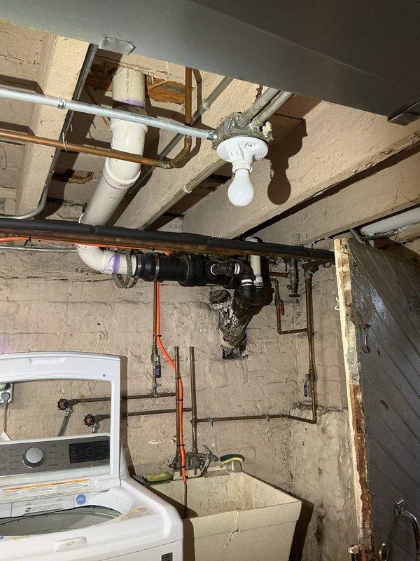 Completed comprehensive drain and sewer estimate for recurring basement floor drain backup issue in 120-year-old residential property. Basement floor drain experiences water backflow during rain events, indicating potential main line obstruction, inadequate drainage capacity, or lack of backwater valve protection. Conducted thorough inspection of basement plumbing system, including floor drain assembly, overhead drainage piping, and visible sewer connections. Documented heavily soiled floor drain opening with significant grime accumulation, cobweb presence, and evidence of standing water staining, confirming chronic backup conditions. Assessed existing plumbing configuration including PVC and copper supply lines, drainage routing through floor joists, and connection points in utility area near laundry equipment. Evaluated age-related deterioration of drainage infrastructure and determined scope of work required for permanent remediation. Provided estimate options for backwater valve in