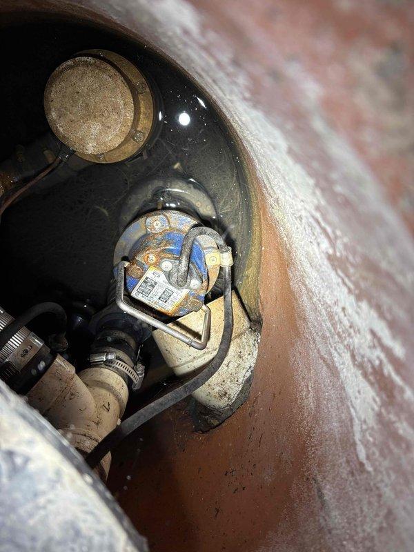 Completed comprehensive plumbing maintenance inspection on historic property. Performed tankless water heater flush and descaling service to remove mineral buildup and maintain optimal efficiency. Inspected sump pump operation and verified proper function and discharge. Evaluated outdoor basement drain for drainage concerns and cleared minor debris obstruction. Addressed leaking outdoor hose spigot connection, identifying worn packing washer causing water seepage around handle stem. Replaced packing washer and tightened compression nut to eliminate leak. Documented significant corrosion on water heater internal components and pipe fittings, noting rust accumulation on threaded connections and mineral deposits on tank interior surfaces. All systems tested and confirmed operational following maintenance procedures.