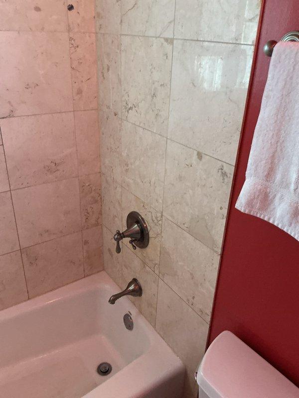 Responded to warranty call for faulty diverter valve in tub/shower fixture. Upon inspection, determined that recently installed diverter valve was malfunctioning despite being new. Documented existing bathroom conditions and plumbing fixtures with photos. Rescheduled service appointment to complete diverter valve replacement and restore proper water flow control between tub spout and shower head.