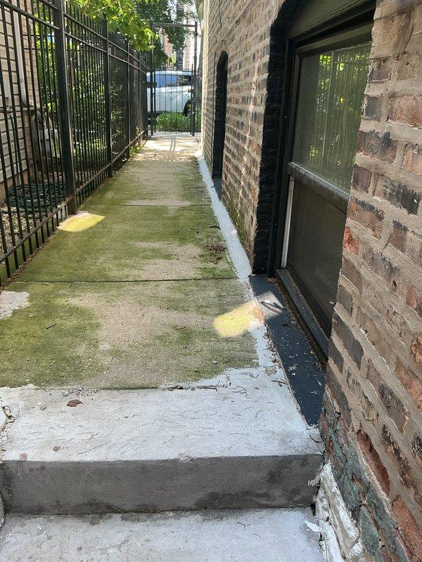 Responded to clogged drain service call at residential property. Upon arrival, inspected outdoor walkway alongside building and interior shower enclosure area where drainage issues were reported. Assessed concrete surfaces showing signs of prolonged moisture accumulation and poor drainage patterns. Identified two floor drains in shower stall requiring attention due to slow drainage and standing water concerns. Cleared blockages from drain lines, restored proper water flow, and verified drainage functionality in both locations. Documented site conditions with photographs for service records.