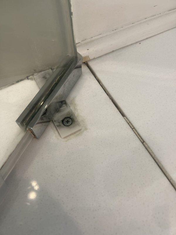 Responded to water leak originating from upstairs bathroom shower area with visible damage to ceiling below. Upon inspection, identified compromised shower door seal and deteriorated grout lines at floor-to-wall junction as primary leak sources. Removed and replaced failed door hardware gasket, resealed chrome hinge assembly, and performed full grout repair at tile corners where moisture infiltration occurred. Tested shower system under pressure to confirm leak resolution and verified no further water penetration to lower level ceiling.
