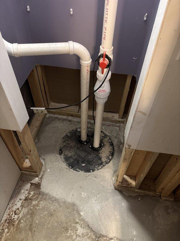Responded to complaint of sewer gas odor detected in first and second floor bathrooms. Performed diagnostic inspection and identified multiple plumbing vents penetrating concrete floor in basement area. Documented existing PVC vent pipe installations with proper floor penetration seals and rubber coupling boots. All vent pipes appeared properly installed with manufacturer specifications visible and appropriate floor sealing mechanisms in place. Recommended monitoring situation and further smoke testing if odors persist to pinpoint exact source of sewer gas infiltration.