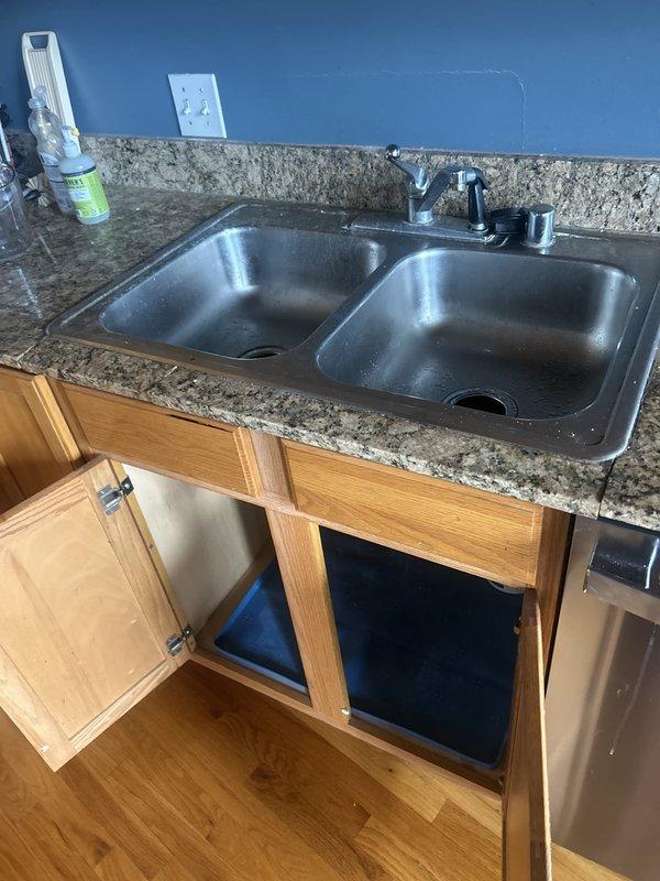 Provided estimate for removal and replacement of kitchen sink and installation of customer-supplied bathroom faucets in dual-handle chrome configuration. Additionally assessed gas leak located near water heater requiring immediate attention for safety compliance. Documented existing fixtures including double-basin stainless steel kitchen sink with chrome faucet and white bathroom vanity with integrated oval basin and dual-handle controls.