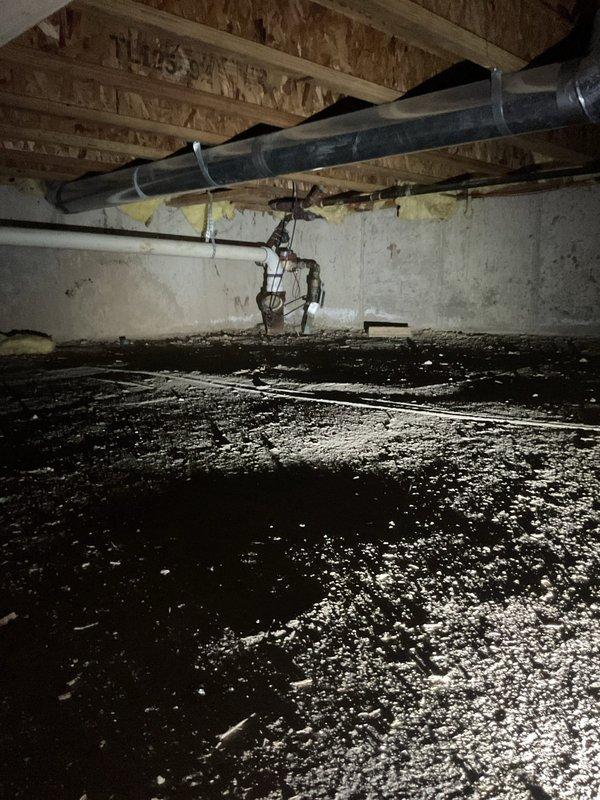Accessed main drain cleanout located in crawl space beneath residence. Navigated through confined crawl space area with vapor barrier flooring to reach main sewer line access point. Successfully cleared and serviced main drain line, restoring proper drainage flow to the plumbing system.