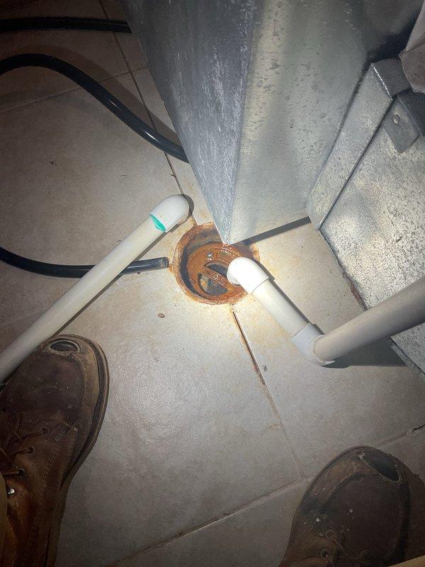 Responded to service call for water intrusion on lower level during rain events. Conducted inspection of exterior drainage systems and interior plumbing penetrations. Identified corroded metal flange at PVC pipe penetration point in ceiling space near HVAC ductwork, which may be contributing to water entry. Documented exterior copper plumbing runs along foundation and evaluated landscaping grade near building perimeter. Customer advised of findings and will be provided with repair options upon technician's return from scheduled time off.