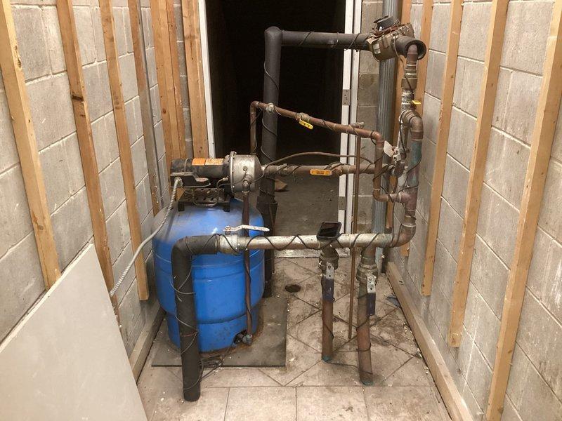 Responded to service call regarding commercial booster pump producing buzzing noise in condo building mechanical room. Conducted thorough inspection of booster pump system, pressure tank, and associated piping network including copper supply lines, valves, and connections. Evaluated pump motor operation, electrical connections via junction box and conduit, and pressure vessel components to identify source of abnormal noise. Documented existing plumbing configuration with pressure tank, shut-off valves, and multi-pipe distribution system. Provided diagnostic findings and recommended corrective actions to address buzzing condition and restore proper pump operation.