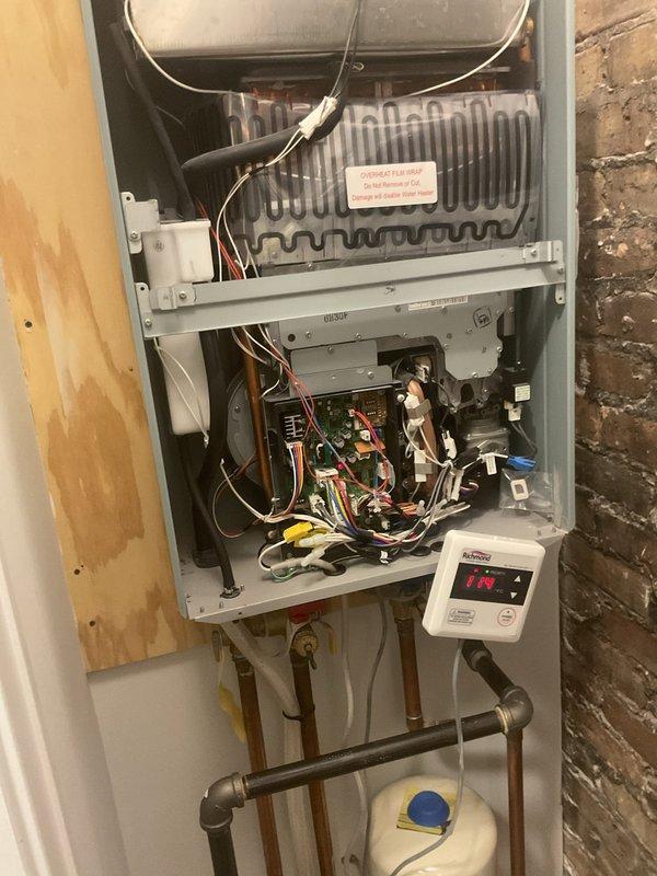 Responded to no hot water complaint on 2.5-year-old wall-mounted tankless water heater unit. Upon inspection, accessed internal components by removing front panel to diagnose system failure. Examined heat exchanger assembly, burner components, electrical control boards, wiring connections, and digital display panel. Evaluated gas supply lines, copper water piping connections, and condensate drainage system for proper operation. Restored hot water functionality to the unit.