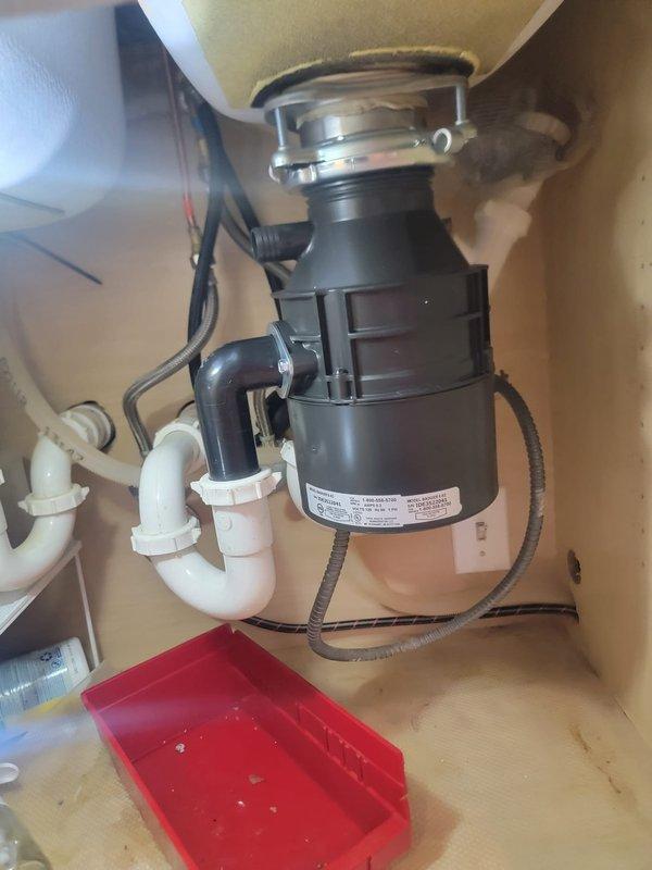 Responded to a fully clogged toilet that remained blocked despite multiple clearing attempts. Upon inspection, discovered the issue was related to the kitchen drain system connected to the garbage disposal unit. Cleared the obstruction in the disposal discharge line and verified proper drainage flow through the P-trap and connecting PVC pipes. Tested all fixtures to ensure complete restoration of drainage function.