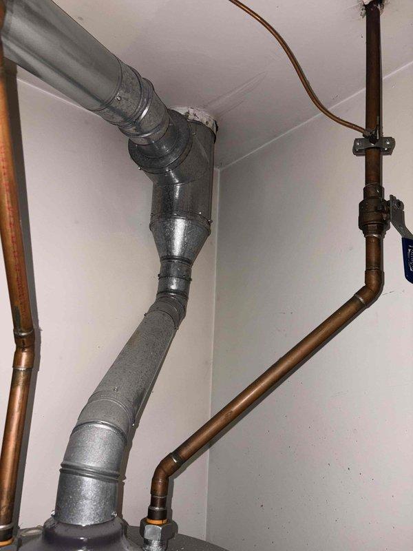 Responded to service call for non-operational Honeywell tanked water heater that failed to reignite. Upon inspection, assessed the existing Reliance brand water heater unit and associated plumbing connections, including copper supply lines, pressure relief valve piping, and exhaust venting system. Documented current installation configuration with copper hot and cold water lines, gas supply connections, and proper venting through metal ductwork. Evaluated unit's operational status and presented repair versus replacement options to proceed with appropriate solution.