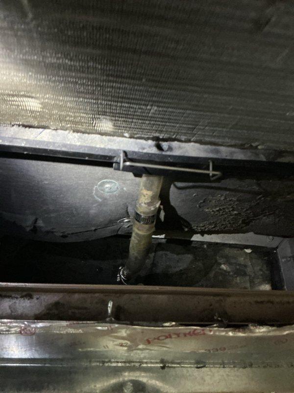 Performed inspection of HVAC system installation in attic space, evaluating furnace/air handler unit, metal ductwork with cross-braced support structure, and associated refrigerant lines. Documented existing system conditions including heat exchanger coils, copper piping connections with brass fittings, flexible metallic tubing, and mounting hardware showing normal operational wear and dust accumulation consistent with system age.