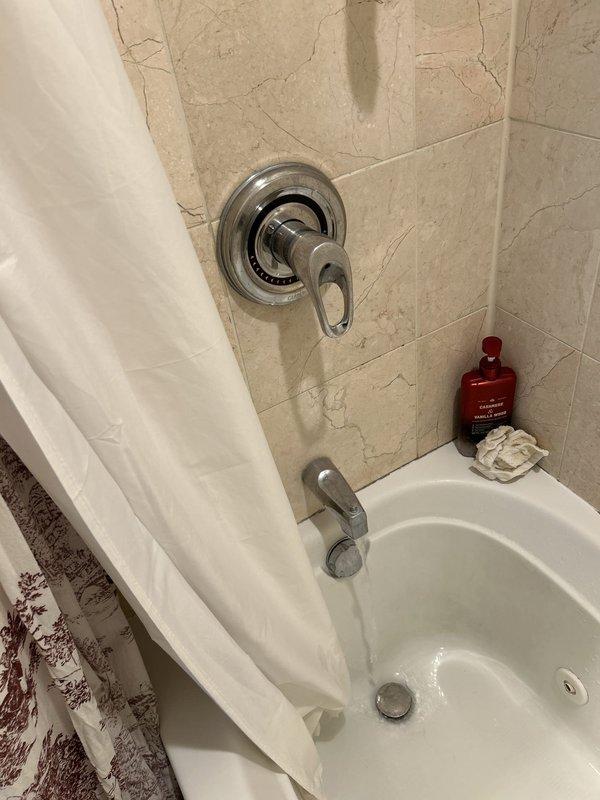 Responded to bathtub faucet that would not shut off completely. Accessed plumbing through wall cavity to locate shut-off valve and isolate water supply to fixture. Diagnosed faulty cartridge in single-handle tub and shower valve as cause of continuous water flow. Replaced worn cartridge assembly, tested operation for proper shut-off and temperature control, and verified no leaks at connections. Fixture now operates normally with complete water shut-off capability restored.