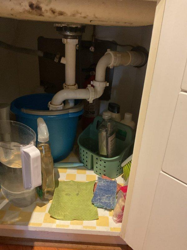 Responded to service call for clogged bathtub and kitchen sink. Upon arrival, inspected both fixtures and confirmed drainage issues. Accessed kitchen sink plumbing through cabinet to assess trap and drain line configuration. Utilized mechanical snaking equipment to clear obstructions from both the bathtub drain line and kitchen sink drain. Successfully restored proper drainage flow to both fixtures. Documented existing conditions including under-sink plumbing layout with garbage disposal unit. Tested both drains after clearing to verify complete restoration of function.