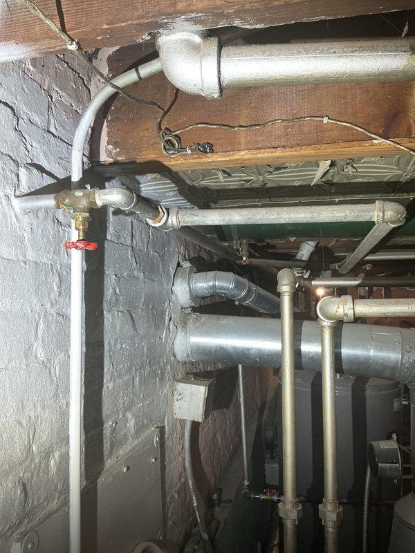 Conducted comprehensive site assessment for plumbing system modifications in basement utility area. Evaluated existing infrastructure including exposed piping, copper lines with brass fittings, PVC drainage, and galvanized supply lines to determine feasibility of installing new 1-inch water line at requested location. Inspected shower water pressure issue, examining supply lines and valve configurations in crawlspace area where mixed piping materials including copper, PVC, and galvanized steel converge at multiple junction points. Assessed current gas line routing and identified relocation requirements to accommodate customer needs. Documented existing conditions including pipe sizes, materials, connection types, and spatial constraints affecting proposed installations. Photographed mechanical room infrastructure showing HVAC ductwork, plumbing distribution, and structural framing to support estimate preparation for water line addition, pressure correction work, and gas line relocation