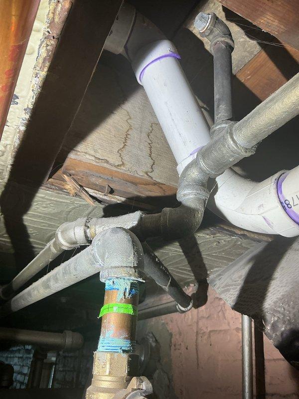 Conducted comprehensive site assessment for plumbing system modifications in basement utility area. Evaluated existing infrastructure including exposed piping, copper lines with brass fittings, PVC drainage, and galvanized supply lines to determine feasibility of installing new 1-inch water line at requested location. Inspected shower water pressure issue, examining supply lines and valve configurations in crawlspace area where mixed piping materials including copper, PVC, and galvanized steel converge at multiple junction points. Assessed current gas line routing and identified relocation requirements to accommodate customer needs. Documented existing conditions including pipe sizes, materials, connection types, and spatial constraints affecting proposed installations. Photographed mechanical room infrastructure showing HVAC ductwork, plumbing distribution, and structural framing to support estimate preparation for water line addition, pressure correction work, and gas line relocation