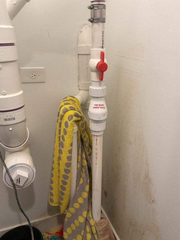 Responded to emergency plumbing call for failed sump pump discharge assembly. Upon arrival, identified a cracked plastic union collar on the Campbell 'The Silencer' silent check valve (model CVUCSL15) that was spraying water during pump operation. The pump had been unplugged and isolation ball valve closed as a temporary measure. Replaced the defective check valve assembly with new unit, reconnected 1.5" PVC discharge piping, and tested system operation to verify proper function and leak-free performance.