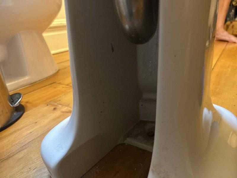 Responded to report of leak on underside of pedestal sink faucet in first floor bathroom. Performed thorough inspection of faucet assembly, supply lines, and drain connections to locate source of water leak. Assessed condition of fixtures and plumbing components, documented findings with photographs, and provided recommendations for repair options to resolve the leaking faucet issue.