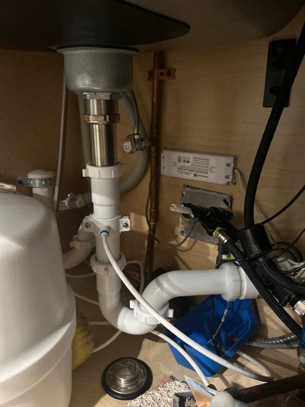 # Reverse Osmosis System Repair

Responded to service call for malfunctioning under-sink reverse osmosis water filtration system. Upon arrival, confirmed customer complaint of storage tank not filling to capacity and continuous water discharge to drain line. 

Performed comprehensive diagnostic evaluation of RO system components located in under-sink cabinet. Inspected pre-filters, membrane housing, storage tank, automatic shut-off valve, and drain saddle assembly. Identified faulty automatic shut-off valve (ASO) failing to close properly when storage tank reached pressure, causing system to remain in constant production mode and allowing treated water to continuously flow to drain.

Replaced defective automatic shut-off valve with new component. Verified proper installation of flow restrictor in drain line. Checked storage tank air pressure at Schrader valve, adjusted to manufacturer specification of 7-8 PSI to ensure optimal tank performance. Inspected all quick-connect fittings and 